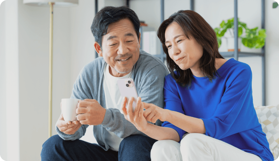 スマートフォンを見ながら相談するご夫婦